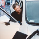 Car mechanic working to remove dent in workshop.